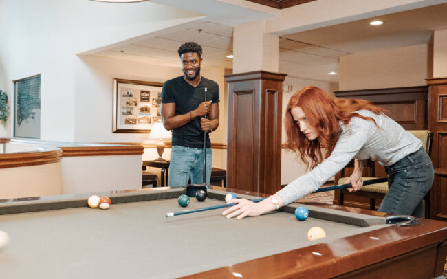 woman concentrating on billiards shot